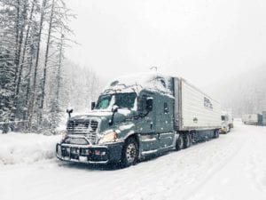 A Prime refrigerated division truck drives through the snow.