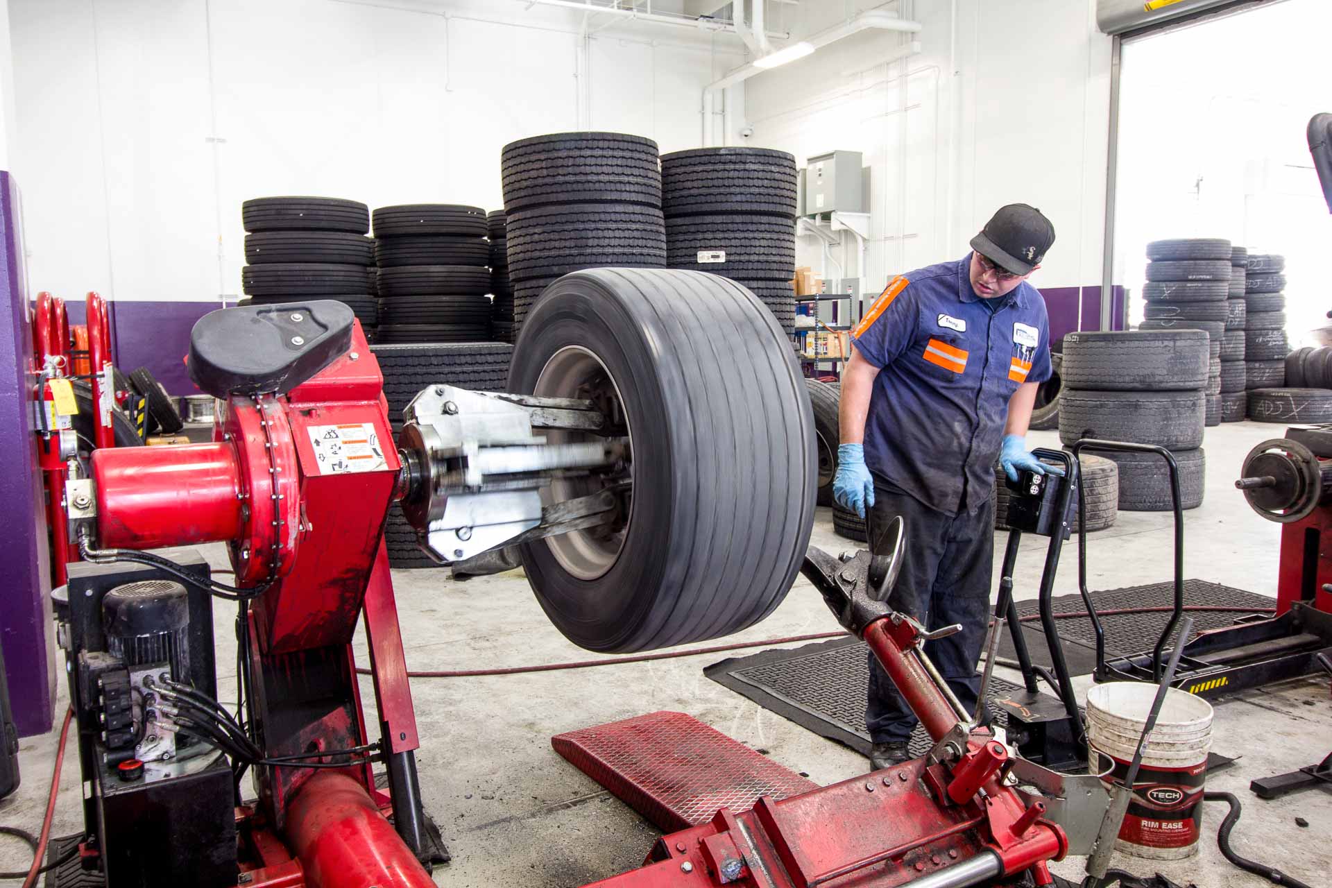 A Prime Inc. mechanic balancing a tire on a tire-balancing machine.