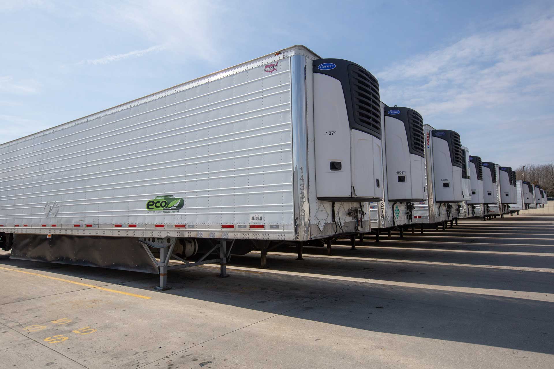 A row of white refrigerated semi-trailers with Carrier reefer units at Prime, Inc.