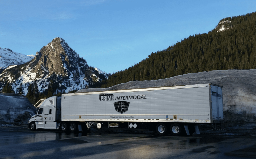Prime Inc. Intermodal trailer and truck in front of a mountain 