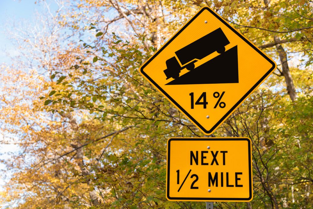 Steep grade warning sign along a mountain road.