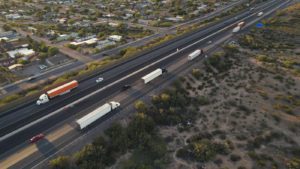 Aerial view of semi-trucks driving down a highway.